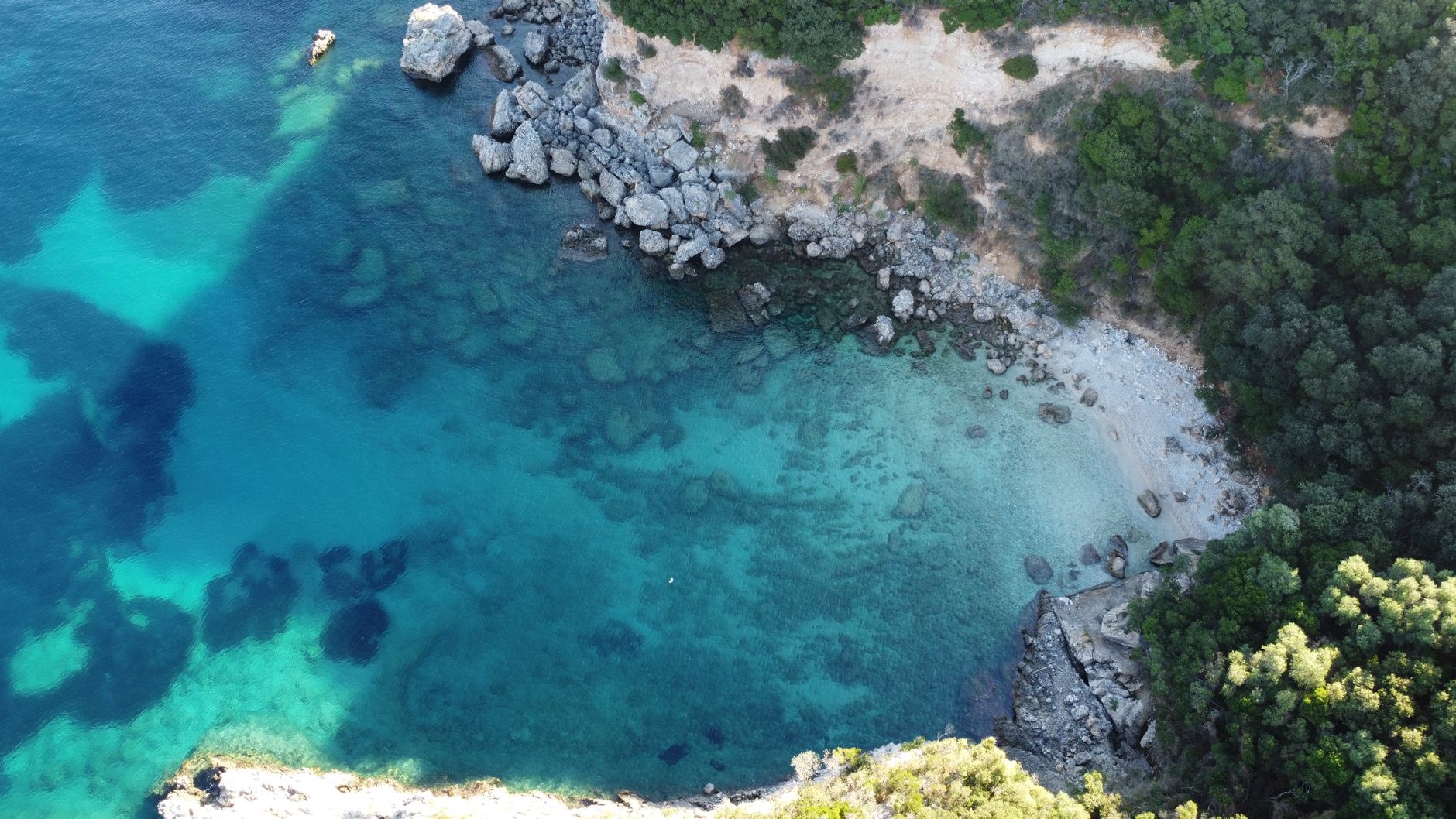 Aerial perspective of crystal waters in Mediterranean cove